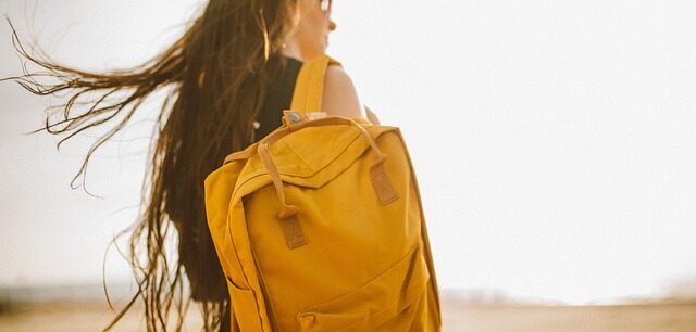 黄色い大きいバッグを肩にかけた女性